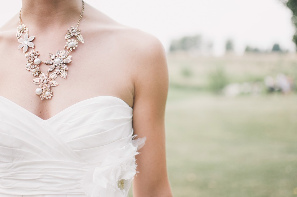 Bride wearing wedding gown and statement diamond necklace.