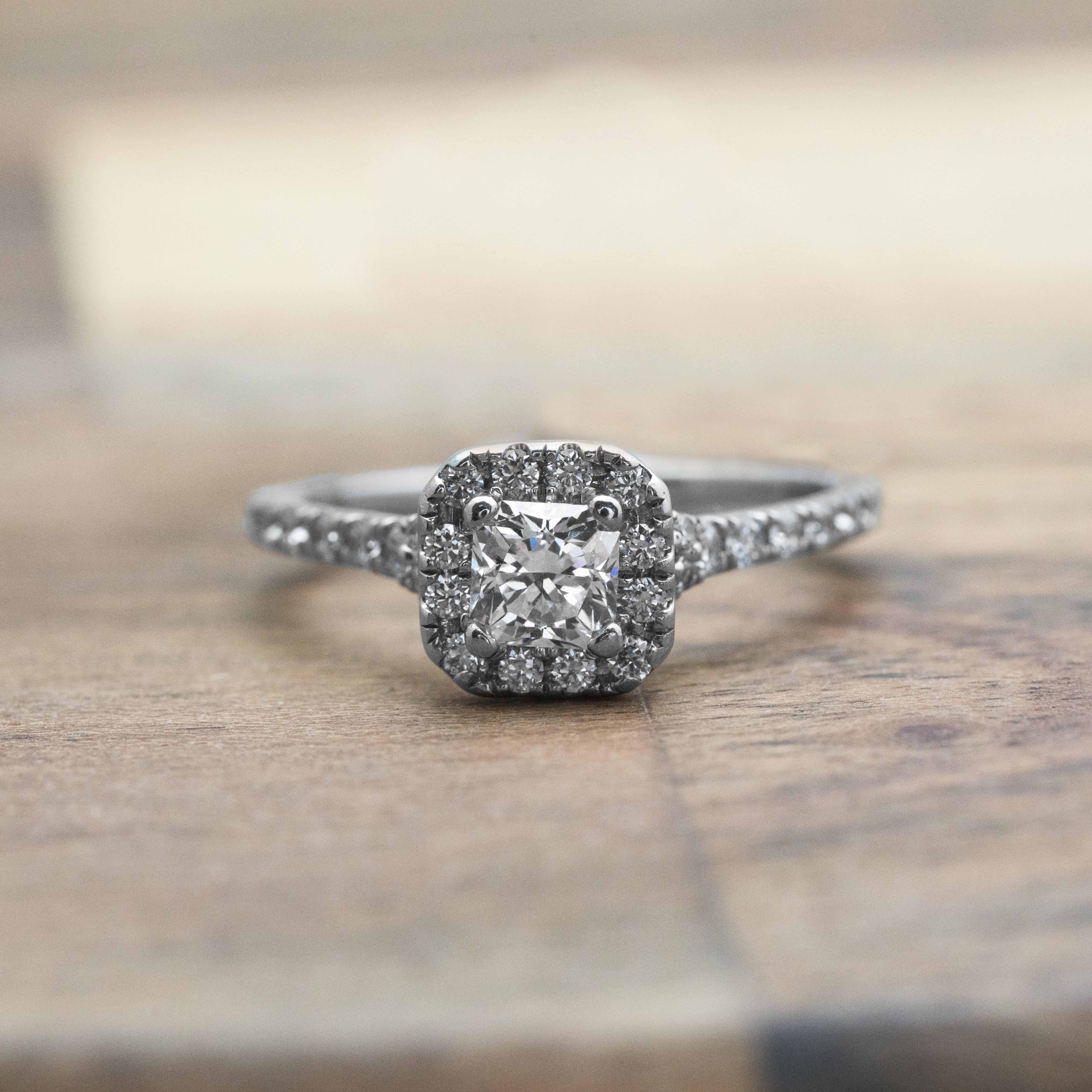 White gold diamond engagement ring with diamond halo and diamonds in the band.
