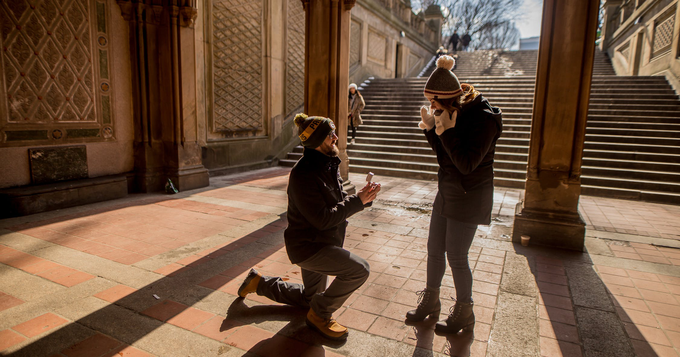 Man proposing to woman outside of historic building.
