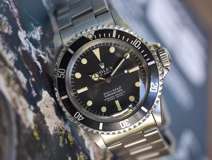 Pre-owned men's Rolex Submariner in yellow gold with a black dial.
