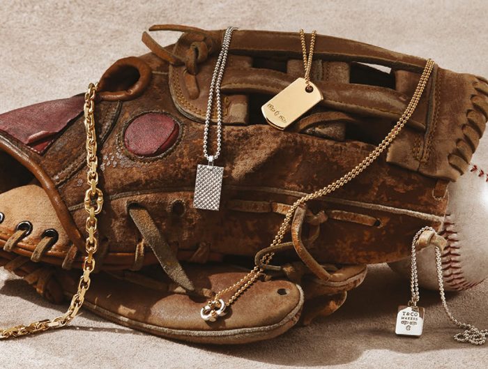 Baseball mitt layered with vintage Tiffany & Co. men’s dog tag necklaces and yellow gold chains.