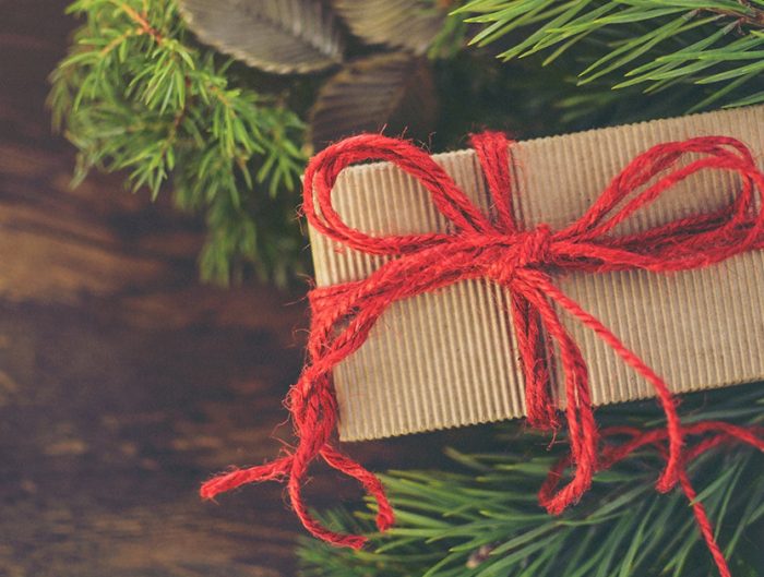 Wrapped gift box next to mistletoe.