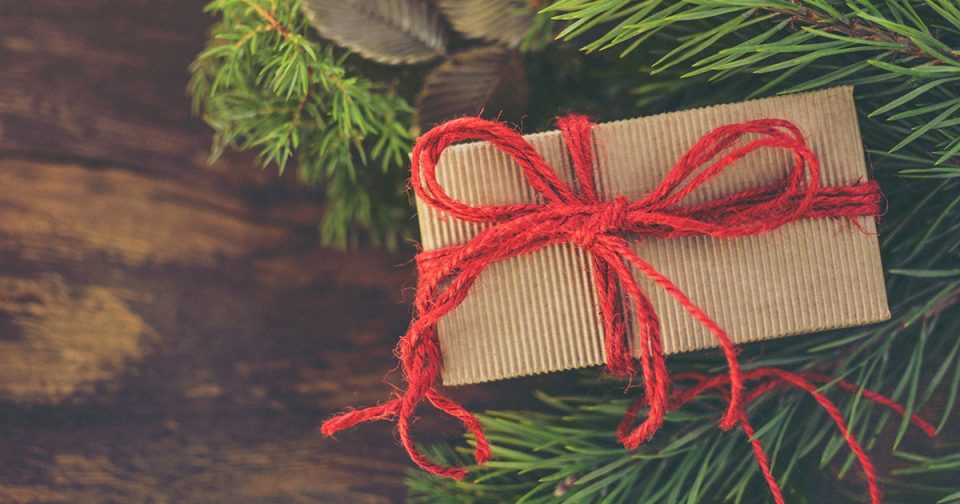 Wrapped gift box next to mistletoe.