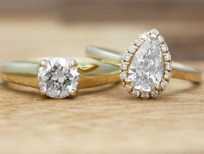 Two yellow gold solitaire diamond engagement rings.