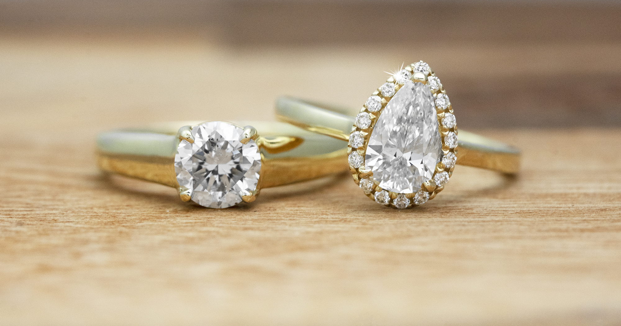 Two yellow gold solitaire diamond engagement rings.