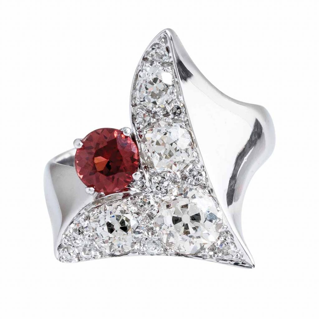 White gold brooch centered with garnet surrounded by diamonds.