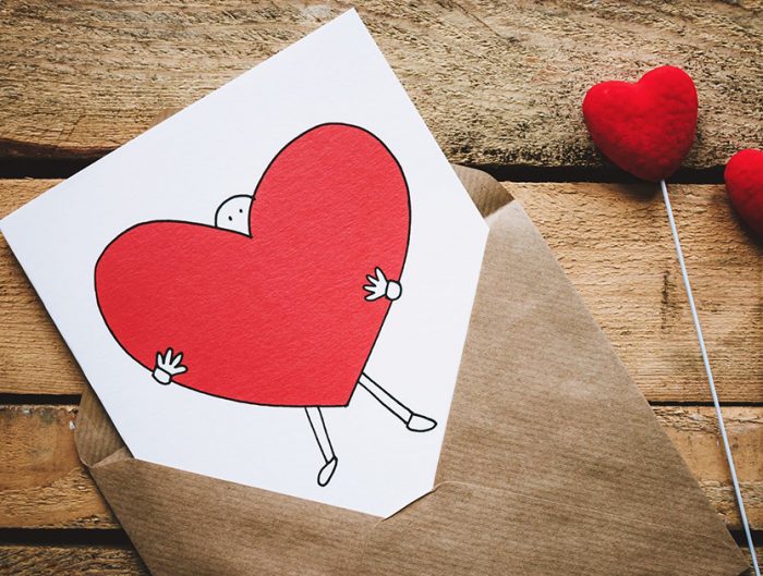 Valentine's Day card and candy on a wooden table.