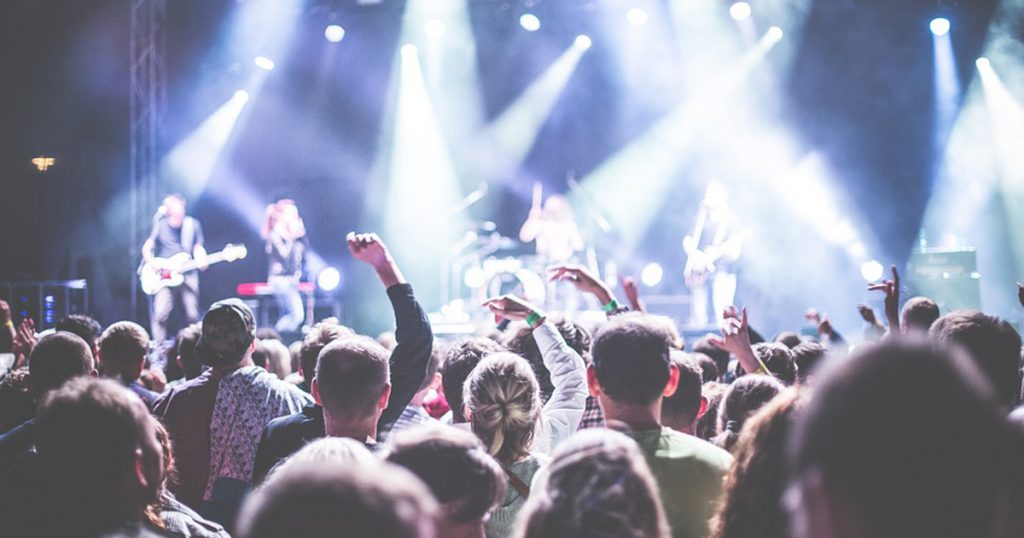 Crowd of people attending concert.