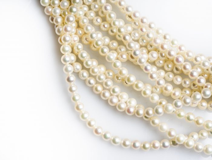 Pile of white pearl strand necklaces.