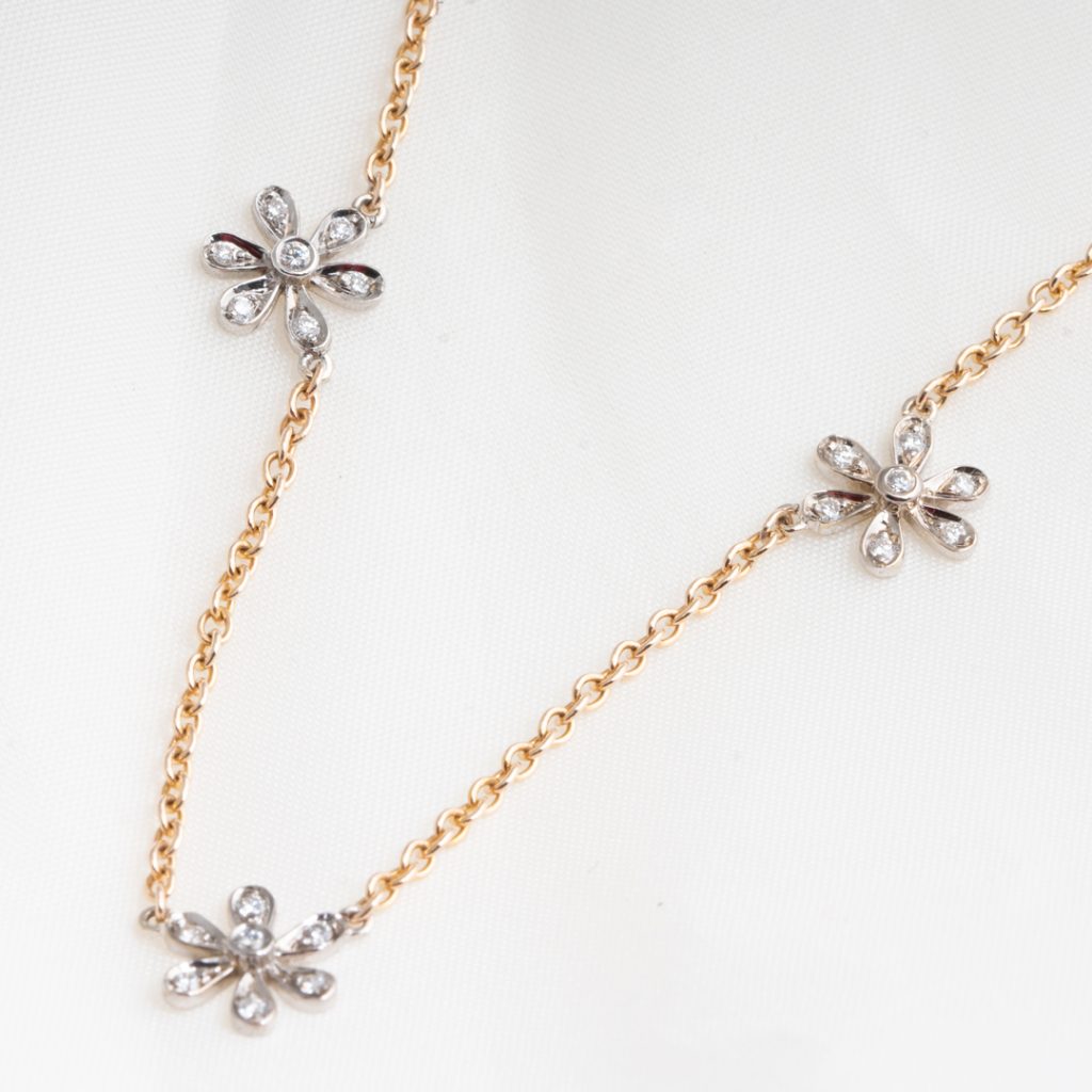 Yellow and white gold three-daisy necklace set with diamonds.