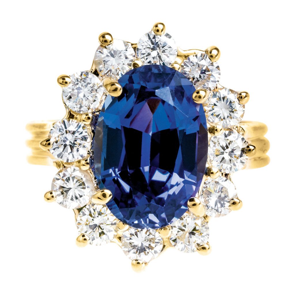 Yellow gold scalloped ring centered with tanzanite surrounded by a diamond halo.