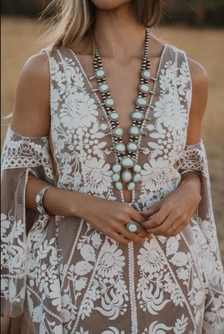 Woman in field wearing a chunky native-style extra-long necklace.