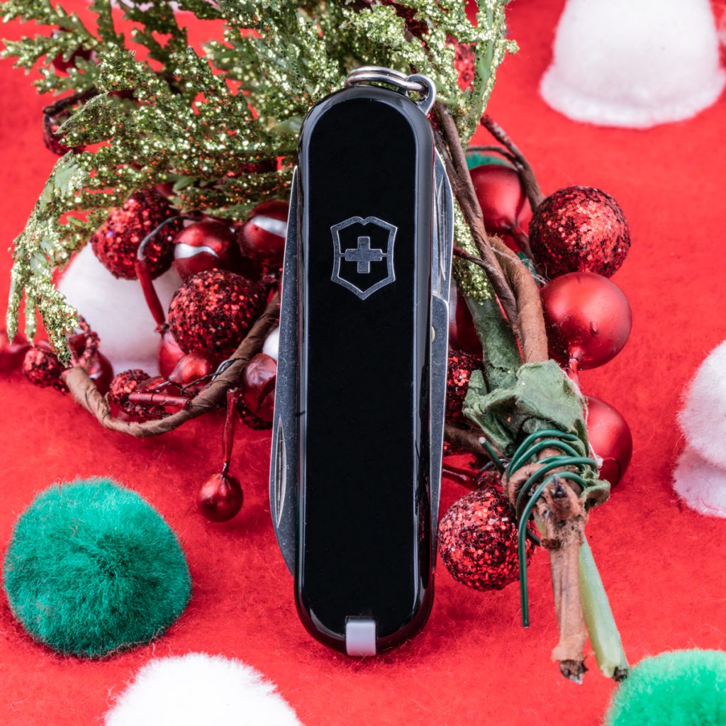 New black Victorinox Swiss Army knife on a mistletoe background.