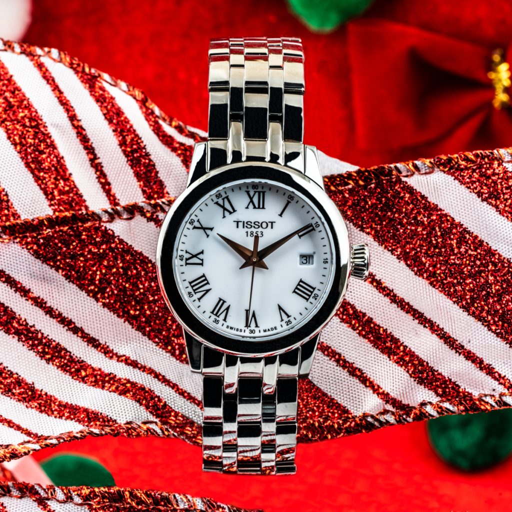 New women’s Tissot Classic Dream Lady 28mm on a red and white striped ribbon background.