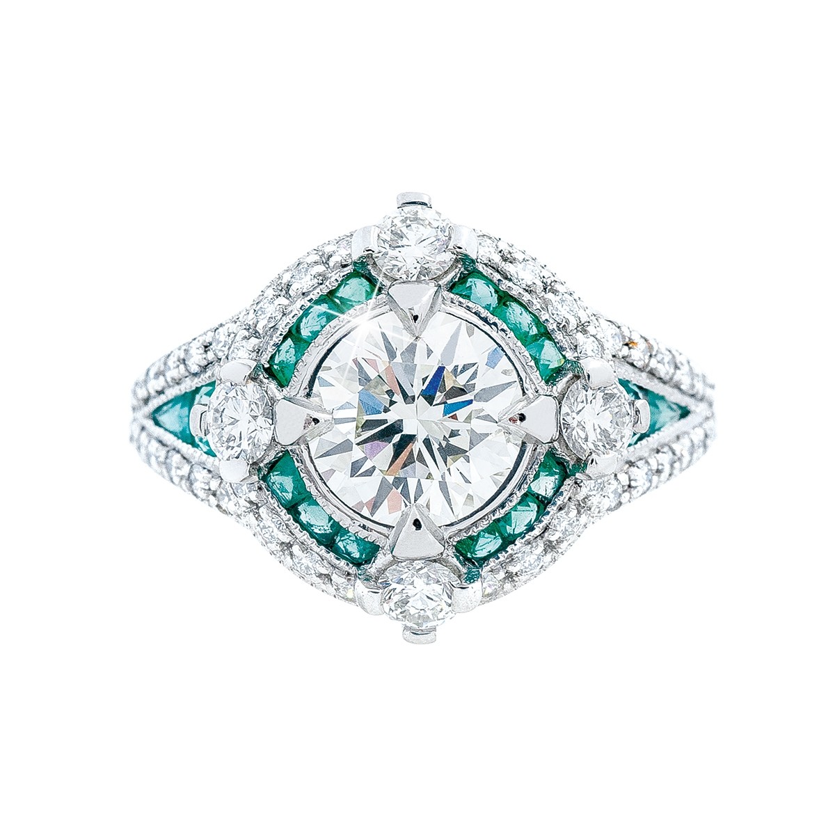 White gold ring centered with a diamond surrounded by diamonds and green gemstones.