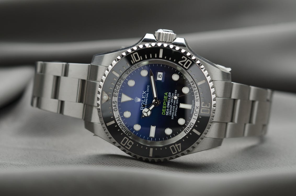 Pre-owned Rolex Deep Sea Sea-Dweller in stainless steel with a blue dial and balck bezel on a gray fabric background.