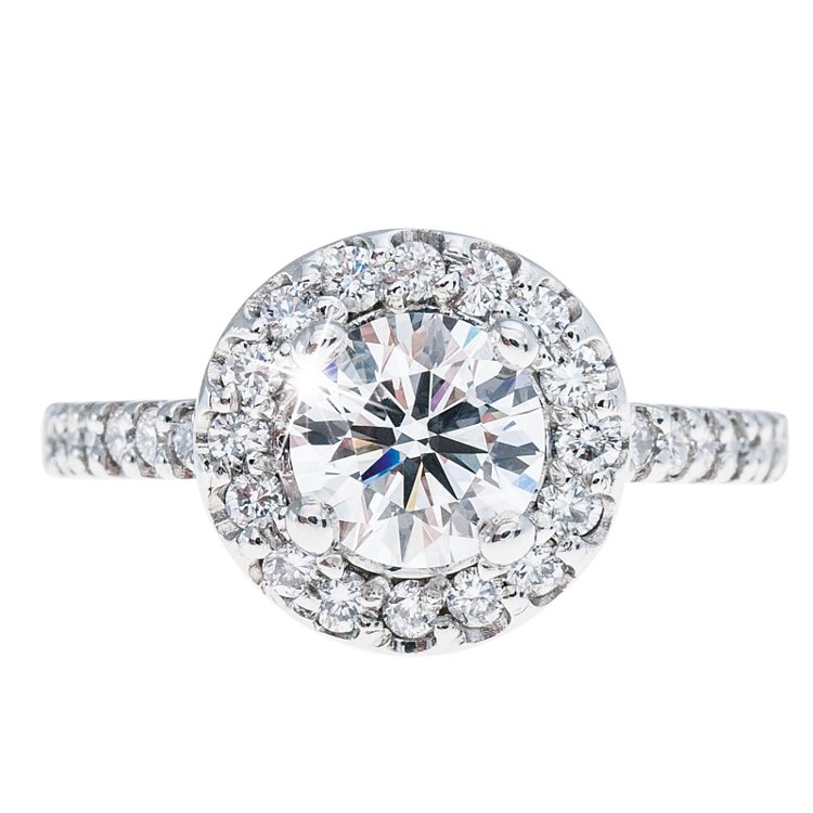 White gold engagement ring centered with a diamond surrounded by a diamond halo.