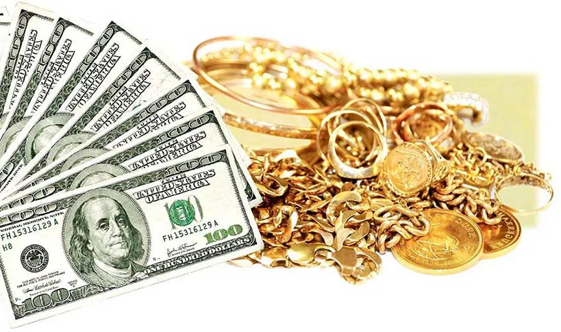 Pile of gold jewelry next to seven $100 bills.