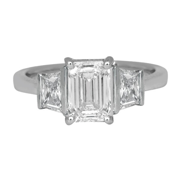 white gold 3-stone diamond ring centered with an emerald cut flanked by trapezoid cut diamonds
