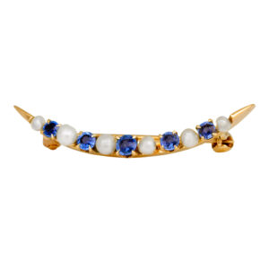 yellow gold crescent brooch set with alternating seed pearls and round blue sapphires