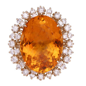 large yellow gold orange citrine oval ring surrounded by a double diamond halo