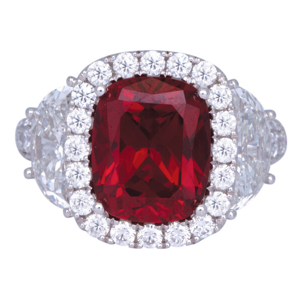 white gold engagement ring centered with a large cushion ruby surrounded by a diamond halo and flanked by diamonds
