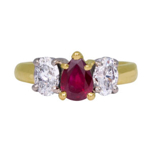 yellow gold 3-stone ring centered with a pear ruby flanked by oval diamonds