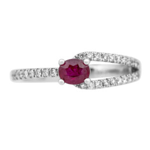 white gold ring centered with an oval ruby and set with round brilliant diamonds in the band