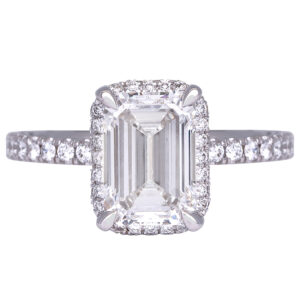 white gold halo engagement ring set with an emerald cut diamond surrounded by round diamonds in the halo and band