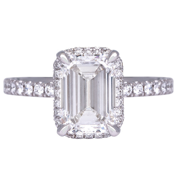 white gold halo engagement ring set with an emerald cut diamond surrounded by round diamonds in the halo and band