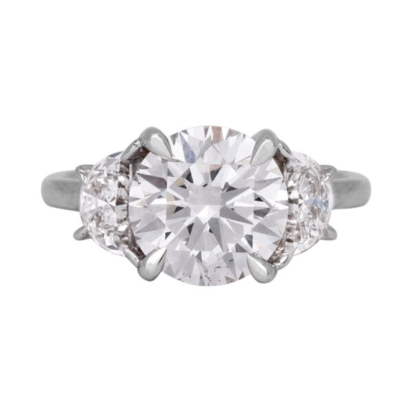 white gold 3-stone engagement ring centered with a large round brillianrt diamond flanked by half moon diamonds