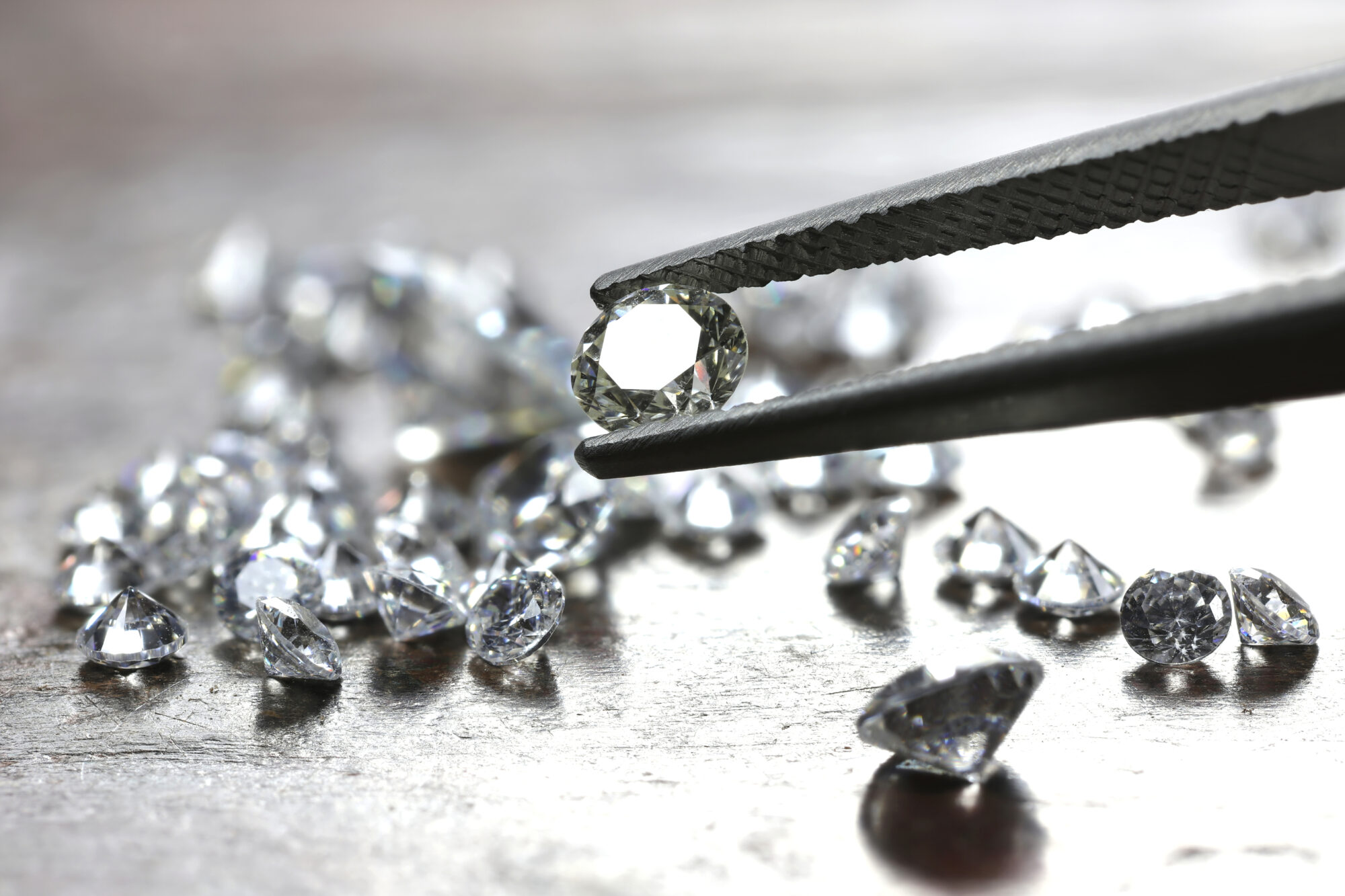 loose diamonds, one held in tweezers