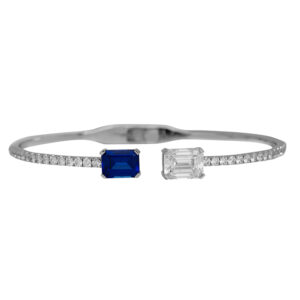 white gold bangle bracelet set with an octagon cut blue sapphire and round brilliant and emerald cut diamonds