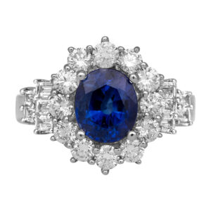 white gold ring centered with an oval sapphire surrounded by round brilliant and baguette diamonds