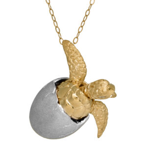 yellow and white gold turtle-in-egg pendant with small diamonds as eyes