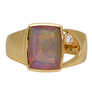 yellow gold ring set with an elongated cushion opal and a round diamond