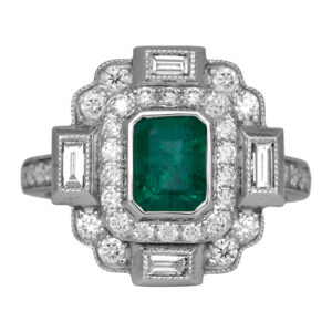 white gold art deco double halo ring centered with an emerald cut emerald surrounded by multiple cuts of diamonds