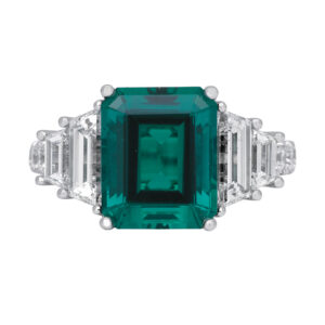 white gold ring centered with an emerald cut emerald flanked by baguette diamonds