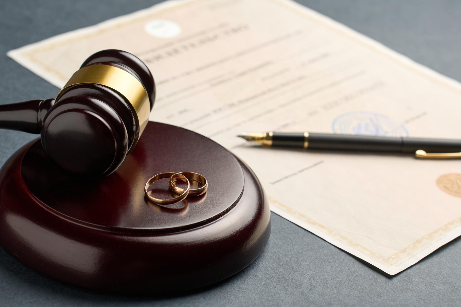 Brown Gavel on a Wooden Base Next to A Court Paper with a Pen on Top