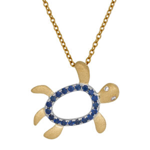 white and yellow gold turtle pendant set with round briliant blue sapphires and one tiny round diamond
