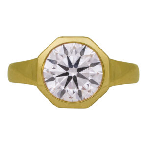 yellow gold octagon ring centered with a round brilliant diamond with an under halo of baguette diamonds