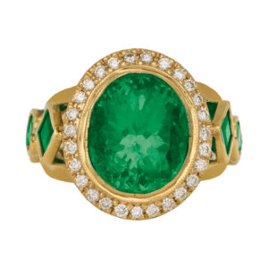 yellow gold ring with a large oval colombian emerald surrounded by round diamond halo and flanked by round and princess emeralds in the band