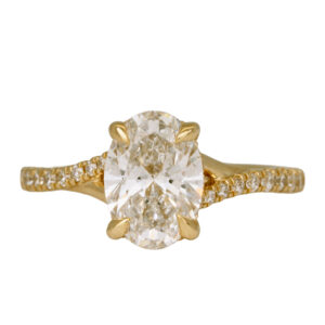 yellow gold underhalo ring centered with an oval diamond surrounded by round diamonds