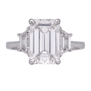 white gold 3-stone ring centered with a large emerald cut diamond flanked by trapezoid diamonds