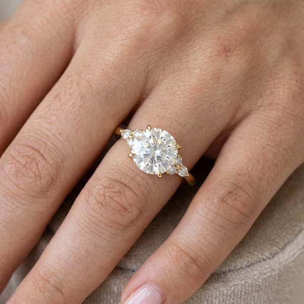 a close up of a lab-grown diamond engagement ring on a woman's finger