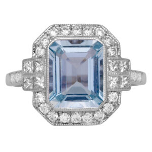 white gold halo ring centered with an emerald cut aquamarine surrounded by round diamonds