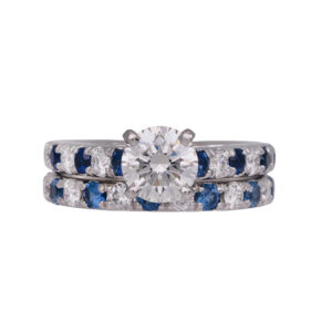 white gold engagement wedding band set set with a large round center and round diamonds and blue sapphires in the bands