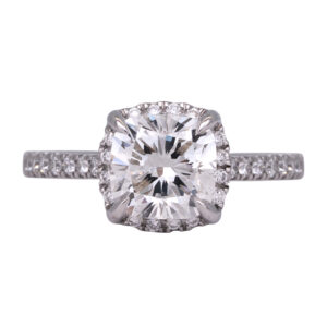 white gold engagement ring set with a cushion diamond and round diamonds in the band