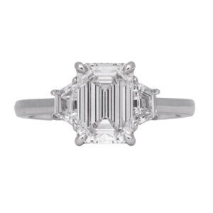 white gold 3-stone ring centered with a large emerald cut flanked by trapezoid diamonds