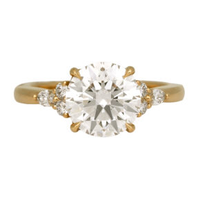 yellow gold engagement ring centered with a large round diamond flanked by round and marquise diamonds